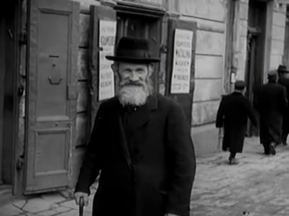 A white-bearded man with a walking stick outside the Eichenbaum shop, Kraków, 1936