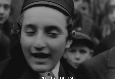 A smiling boy in a cap with payos, from the close of Bryan’s 1936 Kraków reel