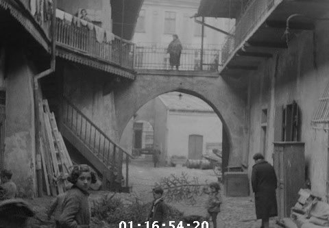 Courtyard with wooden stairs, an arch, and children at Józefa 12, Kraków, 1936