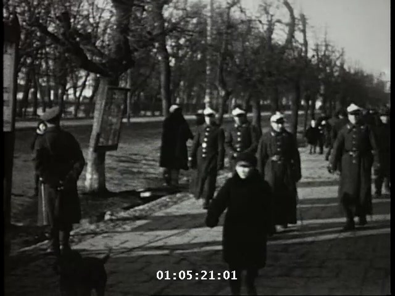 Polish cadets in winter overcoats and military caps walking a tree-lined promenade in Lwów