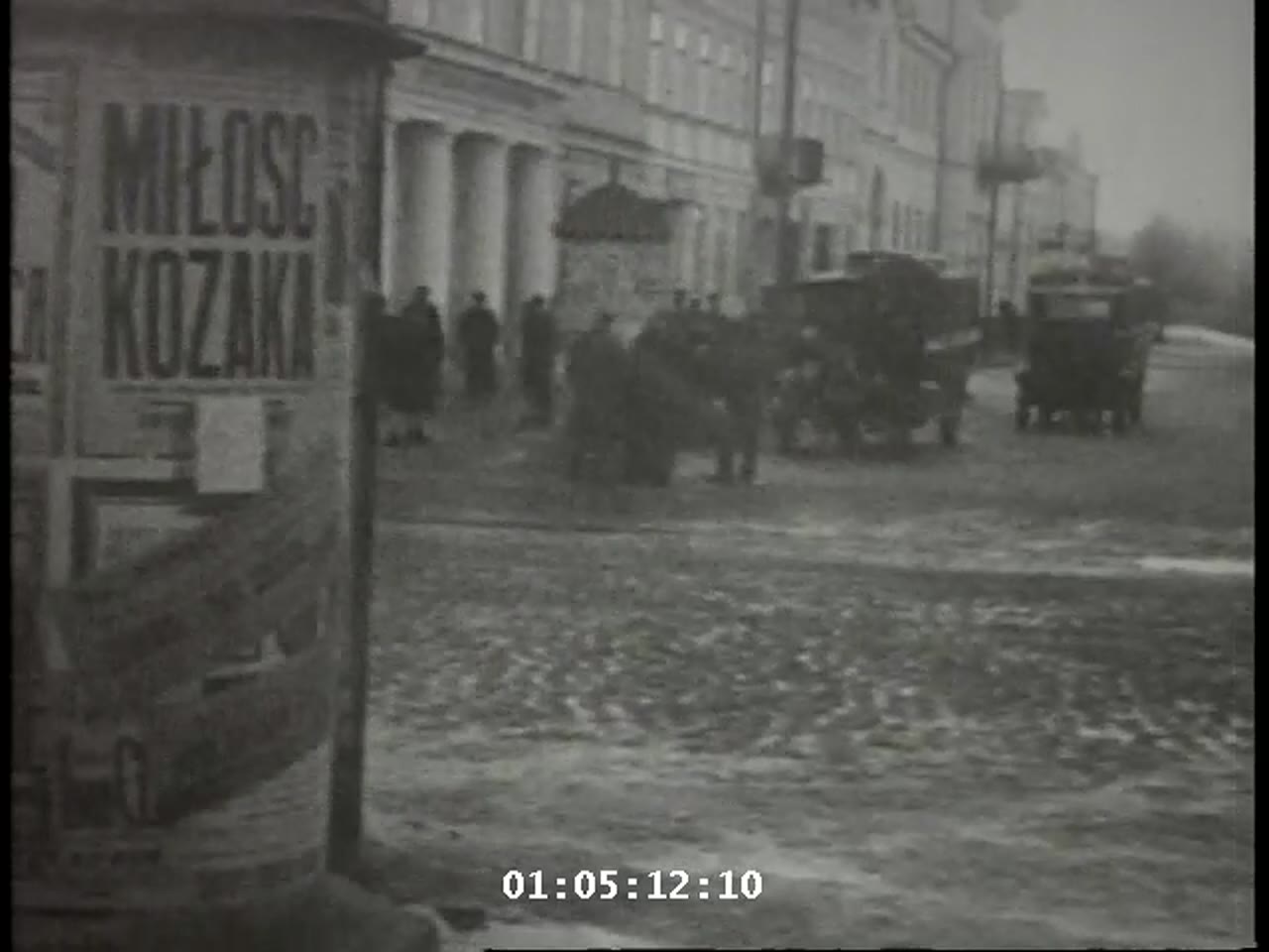 Cylindrical advertising kiosk in Lwów with a poster reading MIŁOŚĆ KOZAKA
