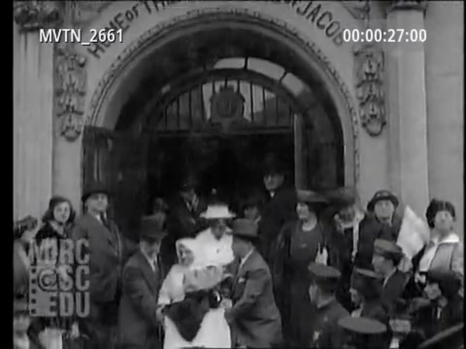 The doorway of the Daughters of Jacob home, with the name over the arch and a crowd outside