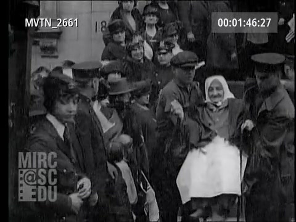 An older resident leaving the home, held on either side