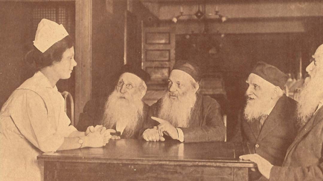 Four residents of the Daughters of Jacob home seated with a nurse