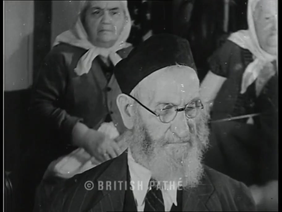 British Pathé close-up of an elderly bearded resident in a yarmulke and glasses at the Hebrew Home card table