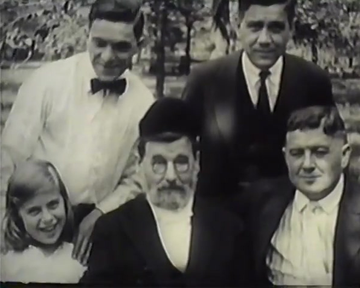 Rabbi Sivitz in a skullcap and glasses with a girl and three young men