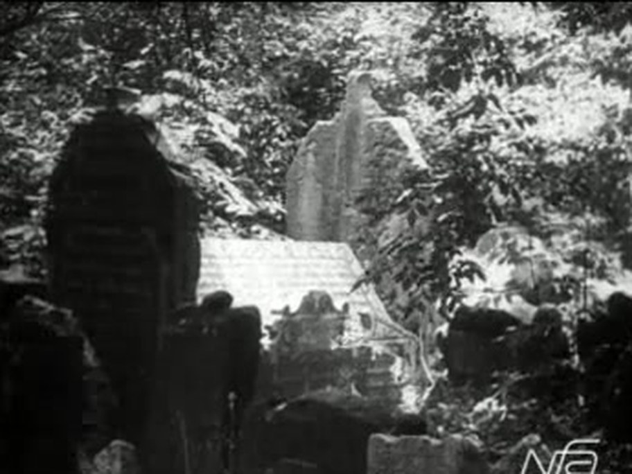 1926 film frame: Mordechai Maisel’s house-shaped grave among trees