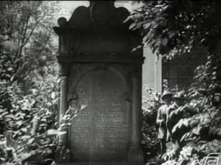1926 film frame: Nefele burial-society memorial among trees, two men in hats