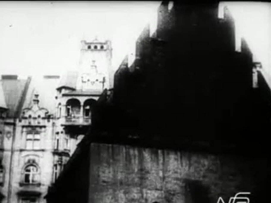 1926 film frame: Old-New Synagogue stepped gable from the street, Town Hall behind