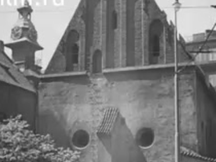 1937 film frame: Old-New Synagogue brick gable from the street