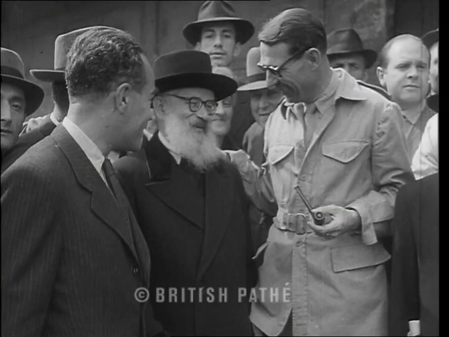 British Pathé frame at about 0:16: Rabbi Herzog with a pipe-smoking UNRRA official