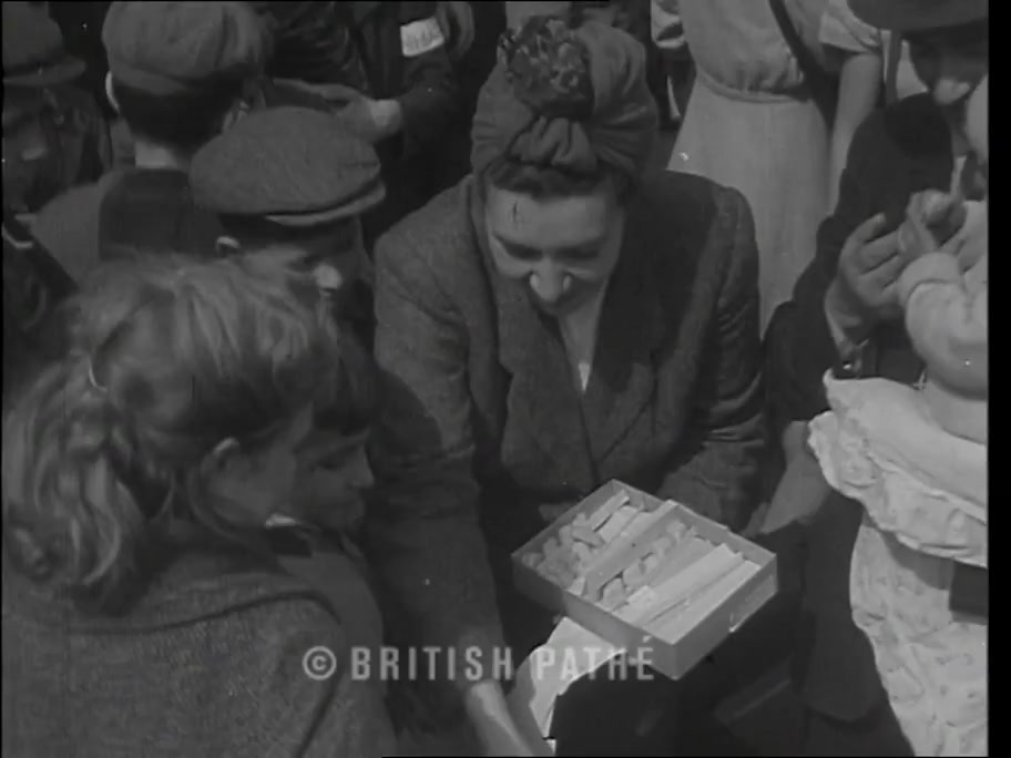 British Pathé frame at about 0:25: Rebbetzin Sternbuch handing sweets to children
