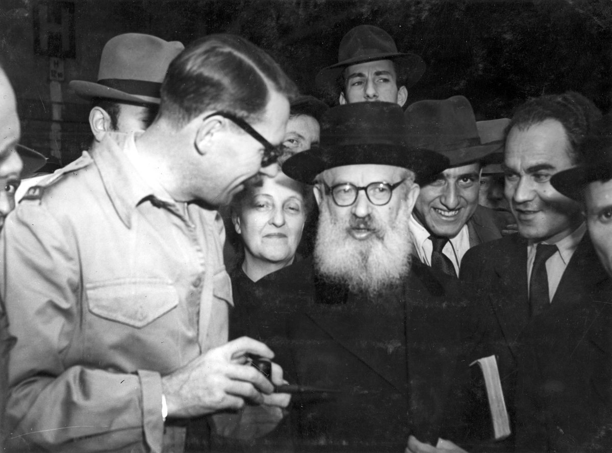 Yad Vashem FA160/34: Chief Rabbi Herzog visiting survivors in Prague, with UNRRA official holding a pipe