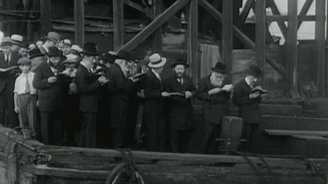 Men and women saying tashlich on a packed East River pier, 1932, from the Bialystoker Synagogue
