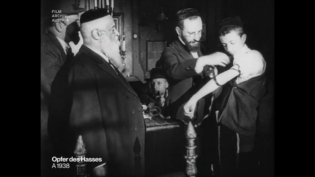Rabbi Yeshaya Furst watching a boy put on tefillin, 1923