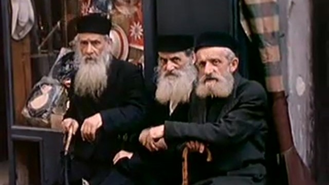 Three older Jews sitting in front of a Warsaw shop window, 1939 color film